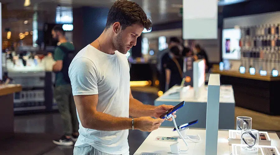 PayMore Reston staff member testing a smartphone during device inspection.